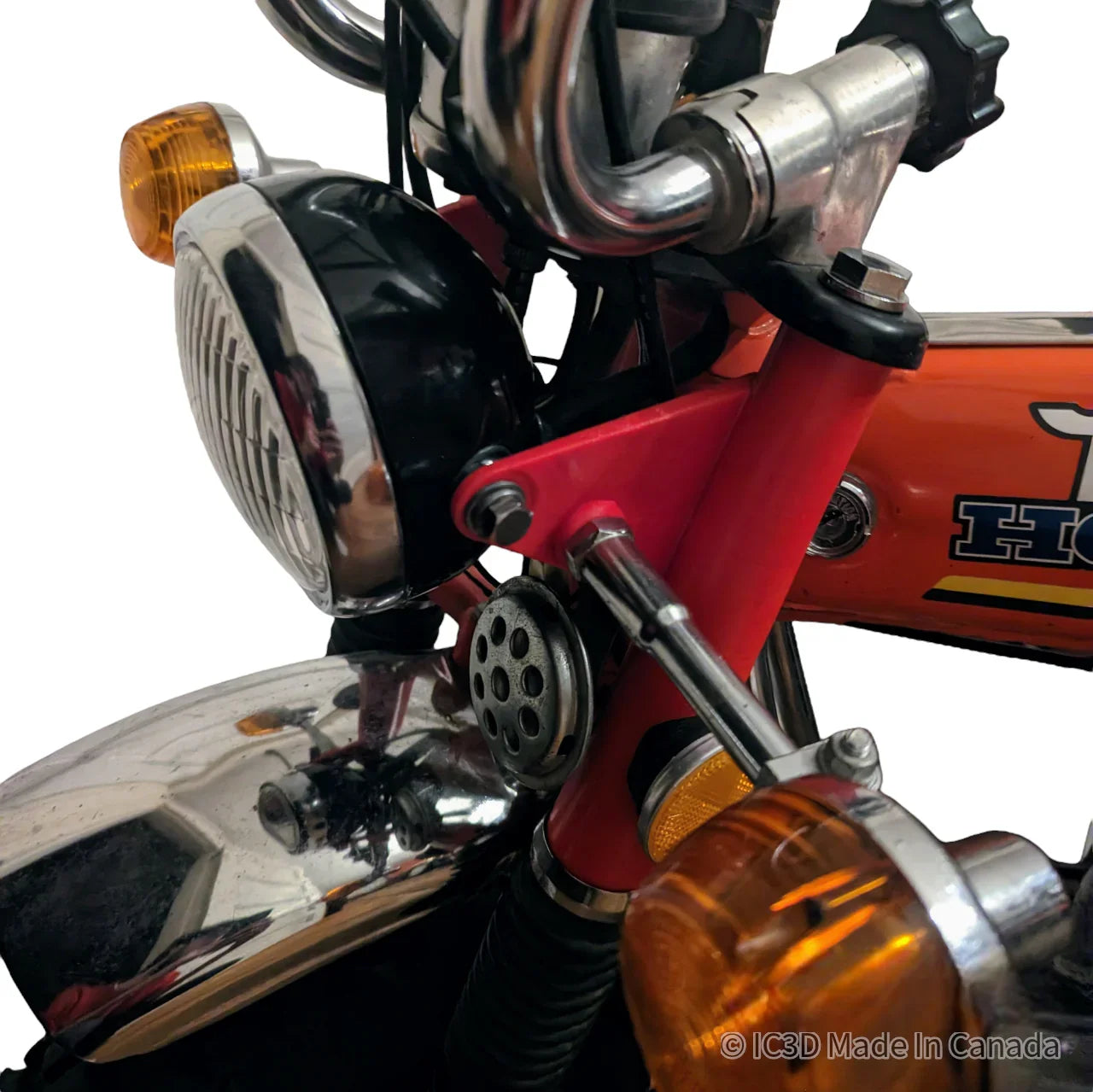 Close-up of vintage Honda motorcycle headlight, turn signals, and chrome fender