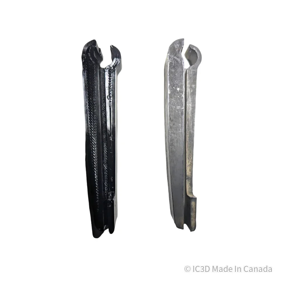 3D printed black plastic tool beside a metal tool, both featuring U-shaped slots, on white background