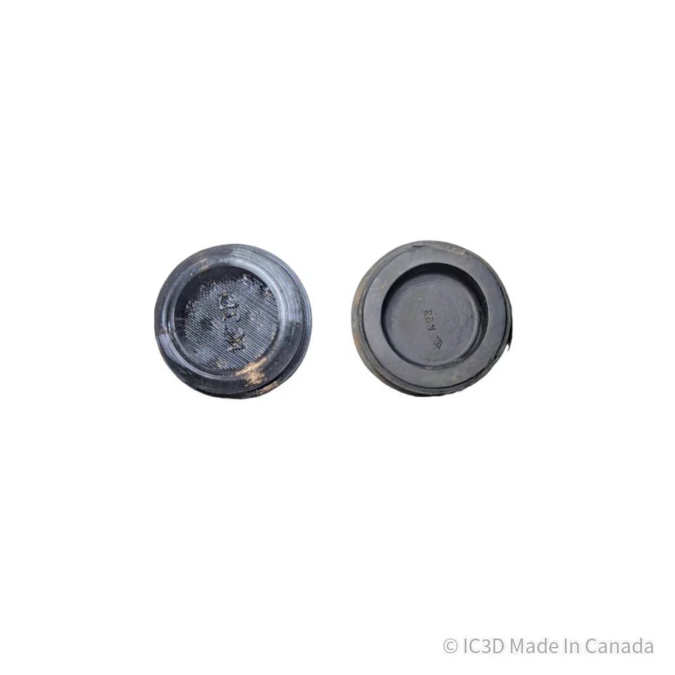 Two black 3D printed plastic end caps on white background, flat and concave side visible