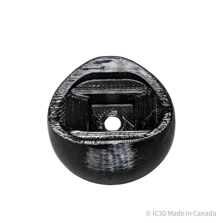 Black 3D printed plastic component with a central hole, circular and textured surface