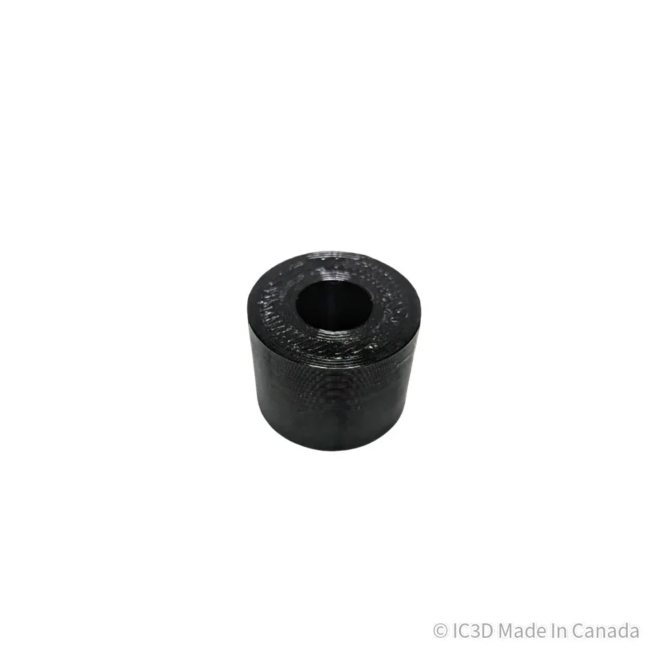 Black 3D printed cylindrical spacer with center hole on white background
